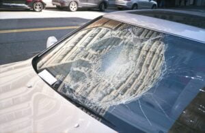 a car with a broken windshield and glass shards all over the dashboard