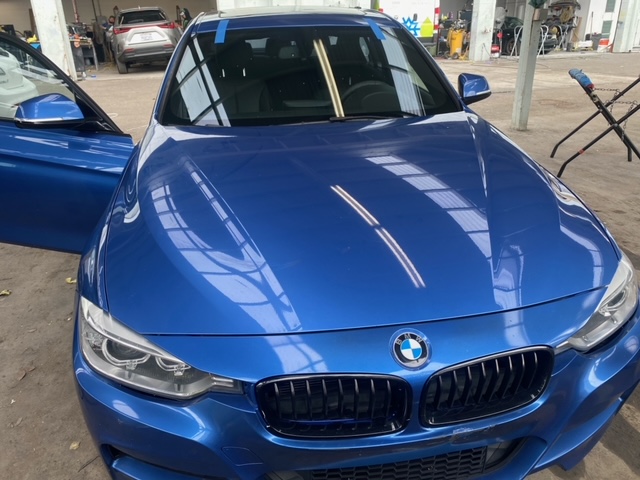 Professional technician repairing windshield with resin injection